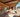 Modern custom camper van interior with cozy seating, wood finishes, desert view