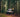 Sprinter adventure van parked in forest, person in yellow jacket on ladder, dog nearby