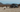 Custom Sprinter van parked in desert with people, dog, and outdoor adventure gear