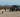 Custom Sprinter van parked in desert with people, dog, and outdoor adventure gear