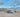 Custom camper van parked in a scenic desert canyon with rocky hills and blue sky