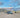 Custom camper van parked in a scenic desert canyon with rocky hills and blue sky