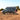 Off-road Sprinter camper van with ladder, roof rack, and rugged tires on a dirt trail