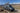 Custom Sprinter van with rooftop solar panels parked in desert mountains, ready for off-grid adventure.