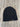 Black ribbed knit beanie with Solid Wood Worx tag on wood floor