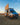 Custom Sprinter van with rooftop solar panel, off-road tires, and open side door in desert at sunset