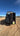 Sprinter van with the Boost Box open on a dirt road and Molle panels on the door