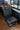 Custom black leather van seat with diamond stitching inside a Sprinter camper van interior