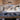 Custom Sprinter van interior with built-in bed, wood cabinets, and scenic mountain view