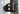 Close-up of a black 180 degree hinge mounted on the rear door post of a gray Sprinter
