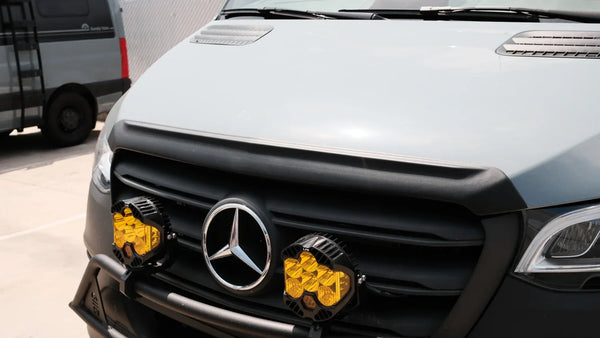 Close-up of the black bug deflector installed on a Mercedes Sprinter hood above the grille