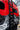 Side ladder and mountain-themed wrap on the red REDARC Sprinter, seen from low angle